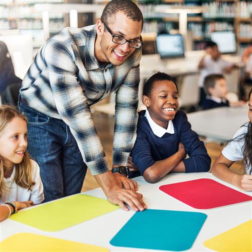 man standing at table with students